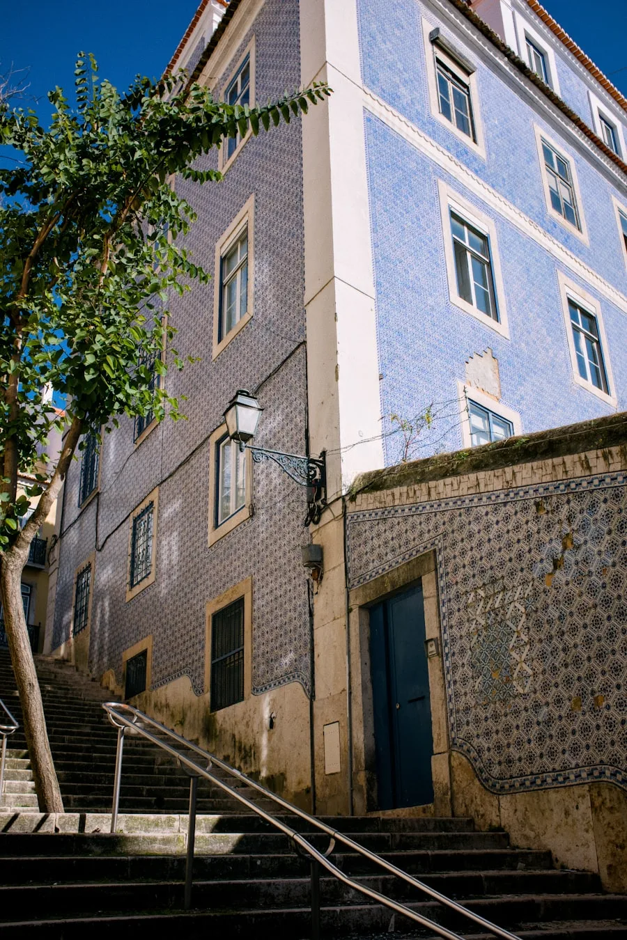 Blue azulejo-tiled building facade with stairway, eastern Lisbon